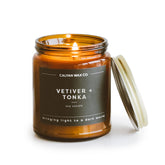 Calyan Wax Co. Bougie Vetiver-tonka dans un verre ambré, ambiance élégante.