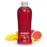 Detoxify Mega Clean verse dans le verre pour une détox naturelle.