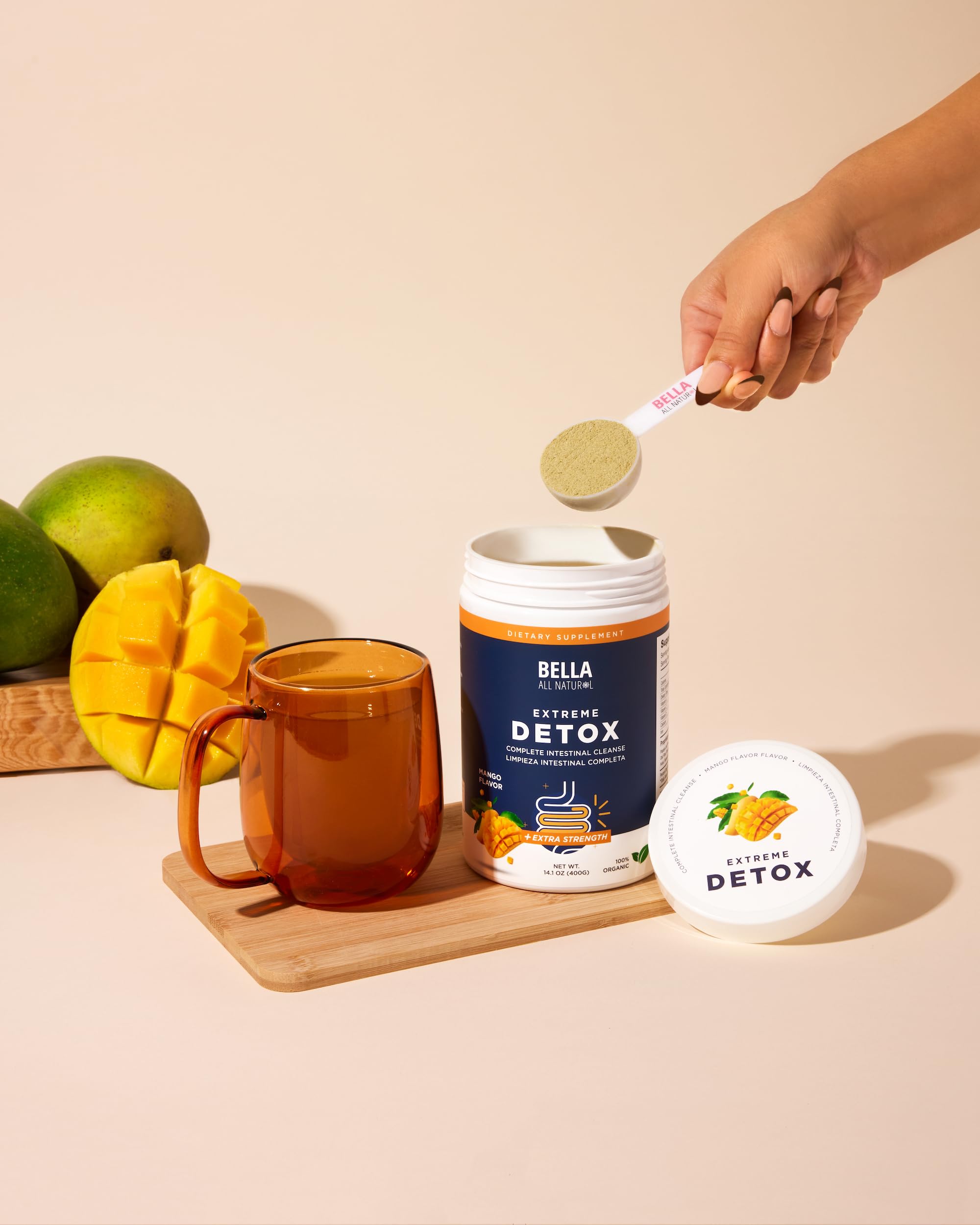 Bella All Natural Detox Mango mélangée dans un verre d'eau pour une boisson rafraîchissante.