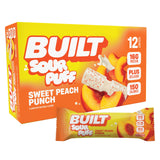 Barre Built Bar goût pêche acide avec texture mousseuse et enrobage sucré.