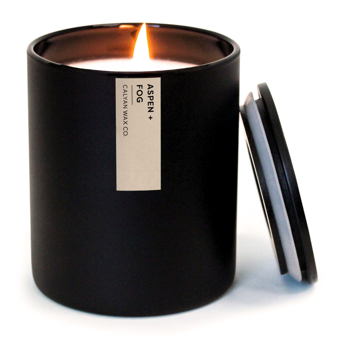 Calyan Wax Co. Aspen & Fog dans un verre noir, ambiance moderne et durable.