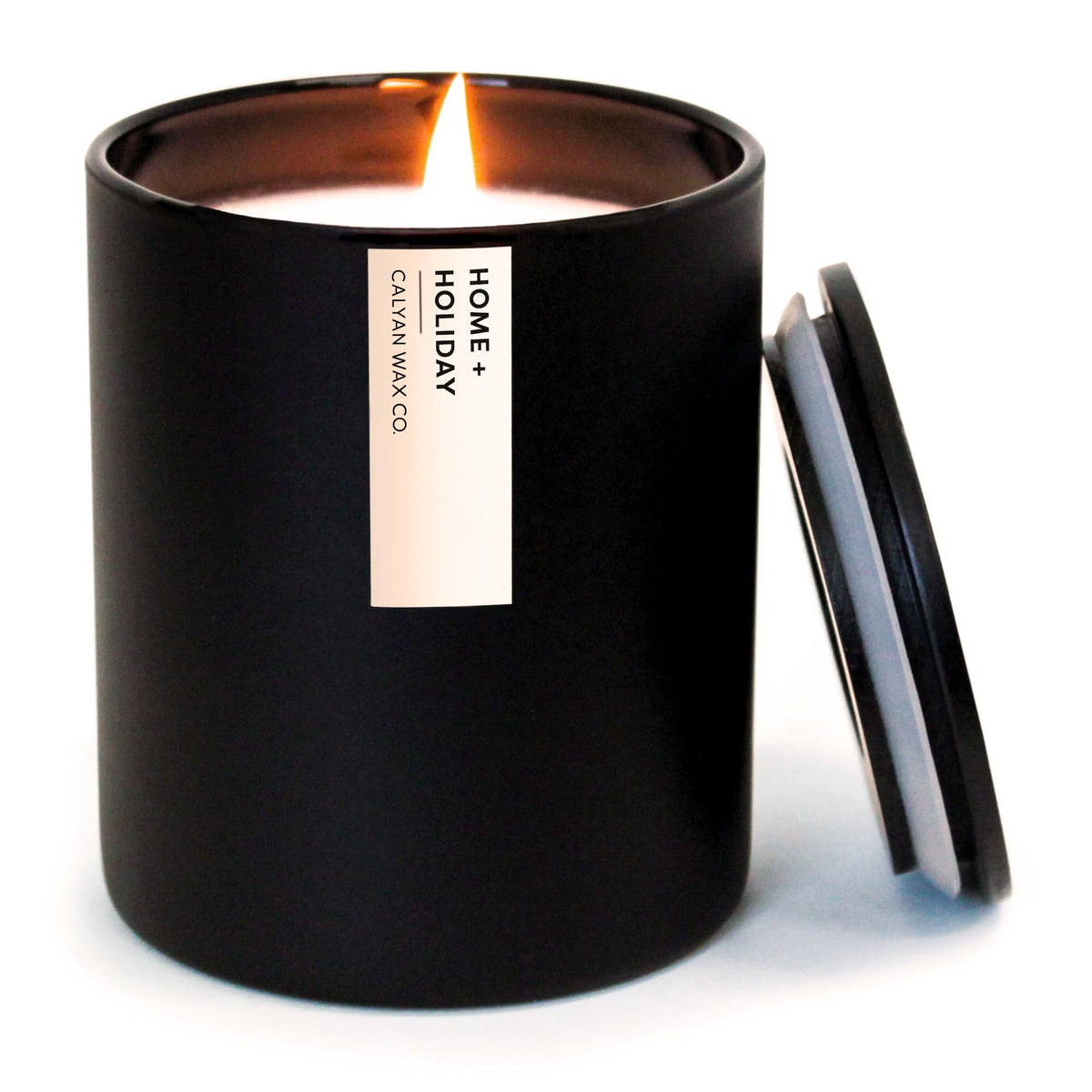 Calyan Wax Co. Bougie Home Holiday dans un verre noir pour une ambiance chaleureuse.
