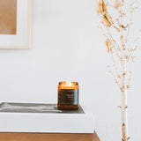 Bougie Calyan Wax Co. en verre ambré, élégant décor pour salon.