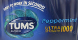 Main tenant une tablette GSK Tums Ultra Peppermint menthe, prête à être consommée rapidement.