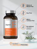 Mains tenant la bouteille Horbäach Vitamine E 1000 UI, commodité d’une dose.