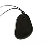 Karelian Heritage pendent shungite sans forme posé sur la peau pour un centrage doux.