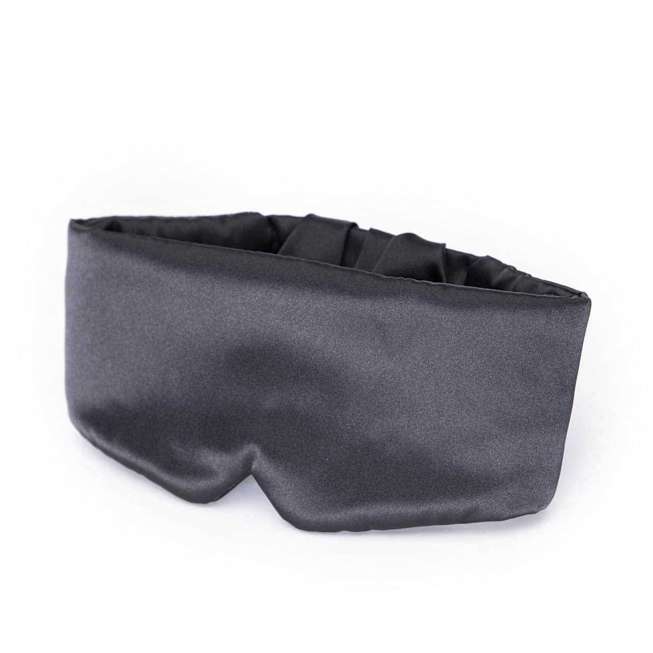 Masque satin Kitsch charbon noir sur un oreiller, usage nocturne.