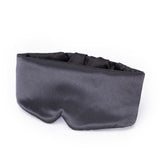 Masque satin Kitsch charbon noir sur un oreiller, usage nocturne.