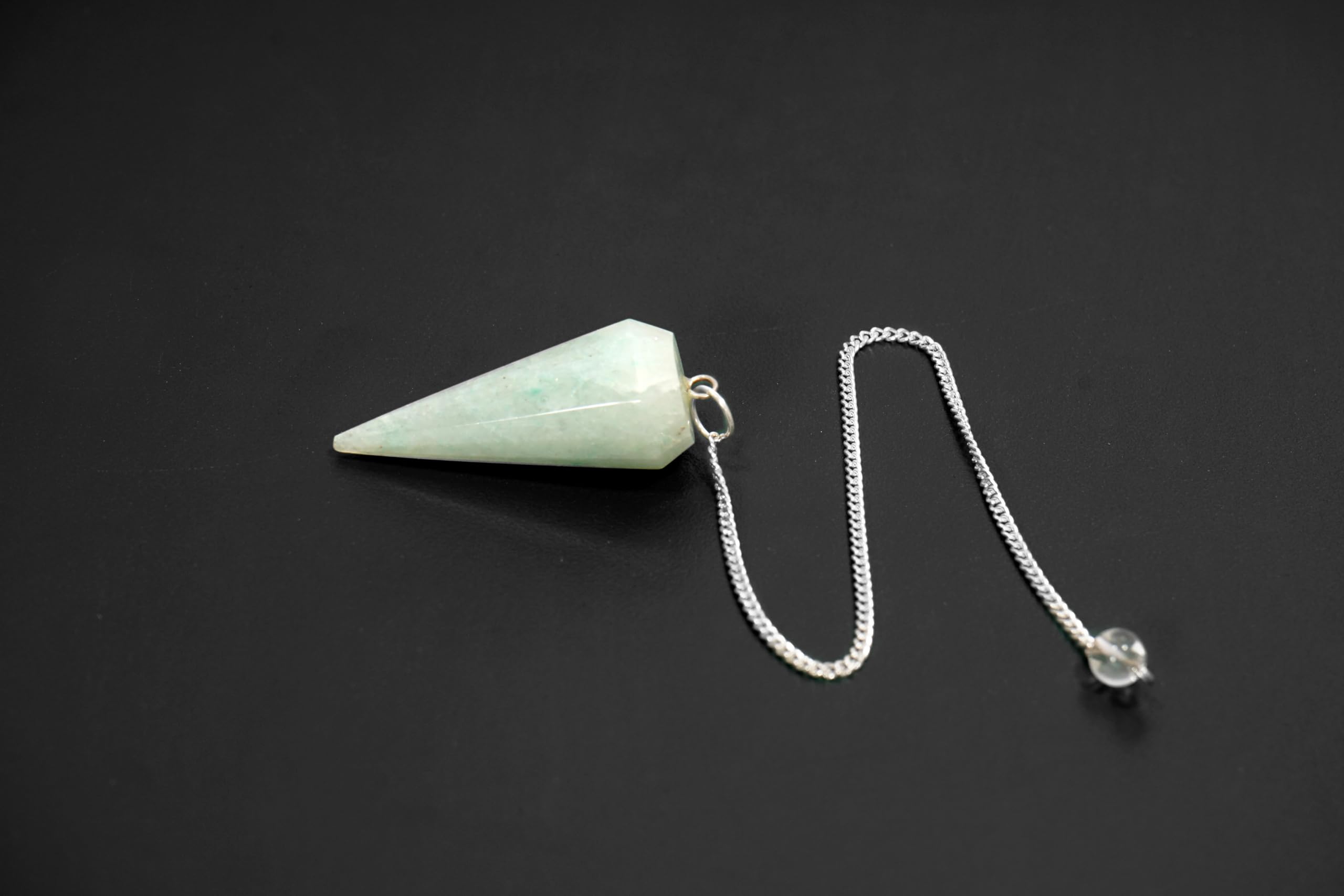 Design du pendule quartz vert L PEDRA & CRYSTAL, mise en valeur du rituel de bien-être.