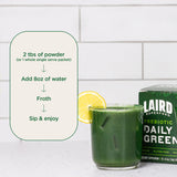 Verre d’eau avec Daily Greens Laird Superfood, couleur verte naturelle et goût frais.