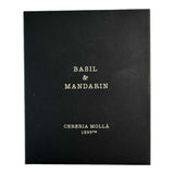 Molla 1899: bougie basilic et mandarine sur table, ambiance lumineuse et décor élégant.