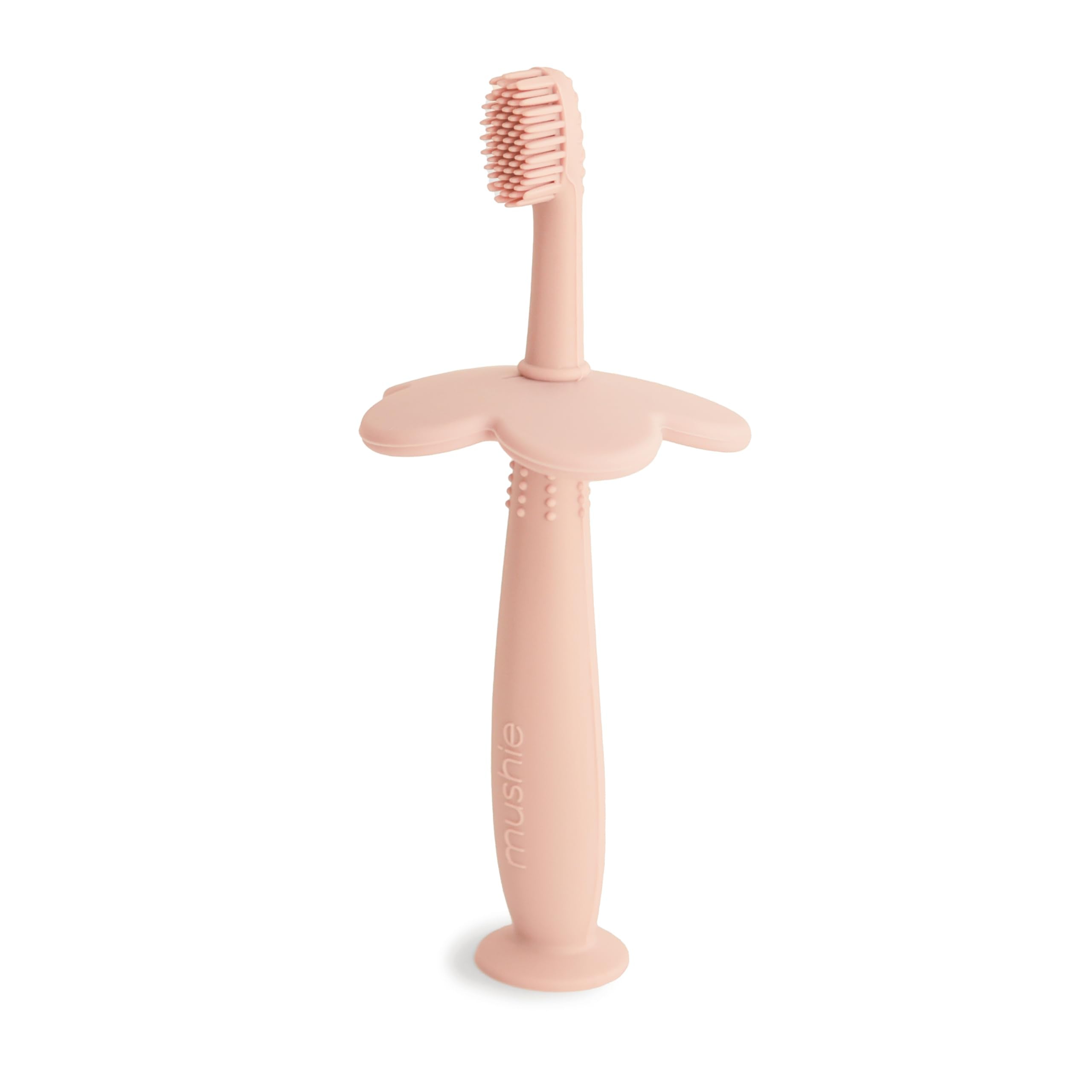 Brosse Mushie d'apprentissage en fleur, rose pâle, favorisant l'autonomie du brossage.