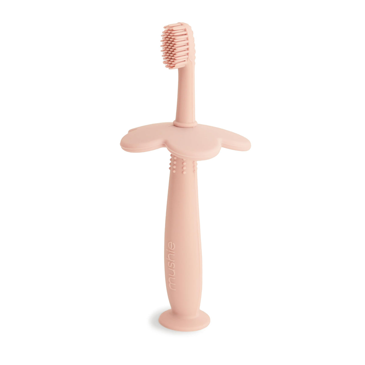 Brosse Mushie d'apprentissage en fleur, rose pâle, favorisant l'autonomie du brossage.