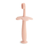 Brosse Mushie d'apprentissage en fleur, rose pâle, favorisant l'autonomie du brossage.