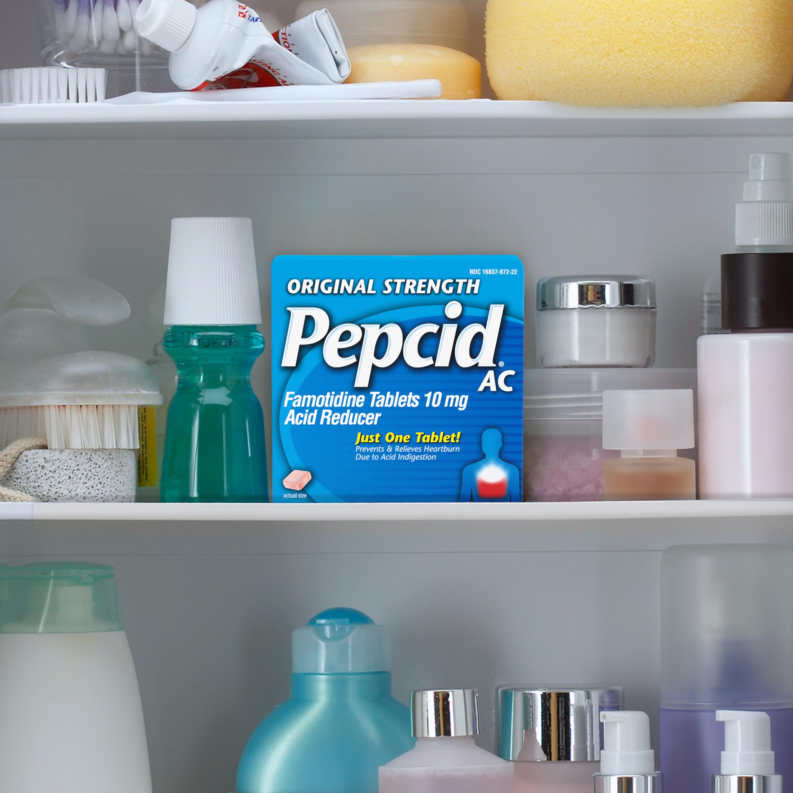 Prise d'une tablette Pepcid AC sans mâcher avec un verre d'eau