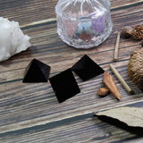 Pyramide Runyangshi sur bureau, obsidienne noire, décoration zen et ambiance professionnelle.