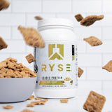 RYSE Up Protéine saveur cannelle-pain-grillé, poudre dans verre, mélange facile et texture lisse.