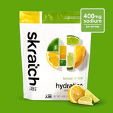 Skratch Labs Poudre d'hydratation avec doseur ajoutant la poudre à l'eau