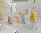 Bougie ours jaune sur table, couleur et parfum floraux pour ambiance chaleureuse.