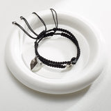 Bracelets tressés en nylon noir avec charm cœur en acier inoxydable.