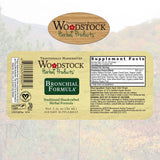 Bouteille sur planche avec étiquette Woodstock Formule Bronchiale, clarté d’utilisation.