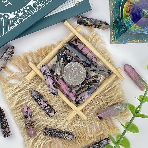 Main tenant une pierre rhodochrosite pour focalisation et calme avec YATOJUZI.