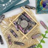 Main tenant une pierre rhodochrosite pour focalisation et calme avec YATOJUZI.